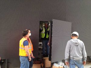 Workers installing Barco door display
