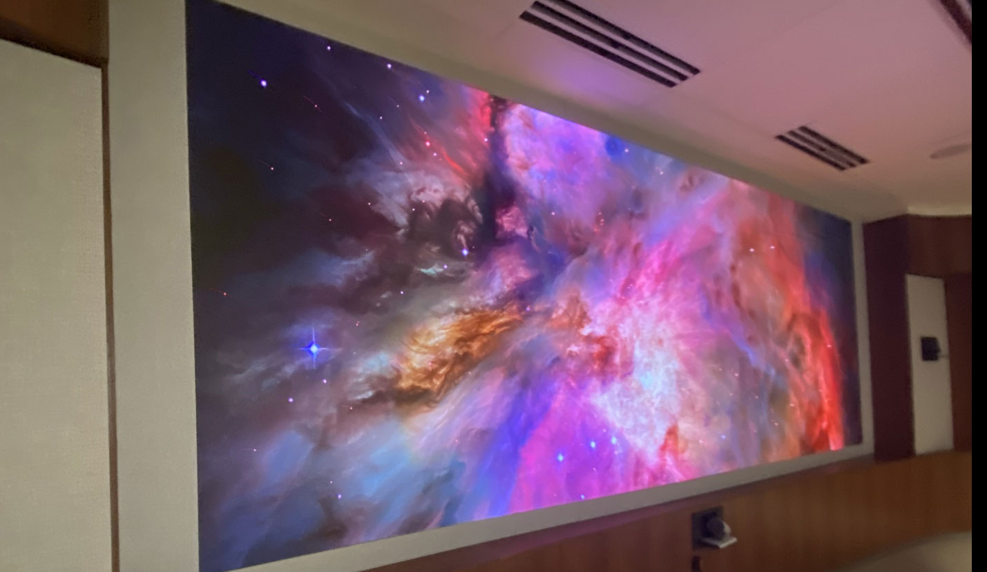 Large display in meeting room showcasing galaxy image