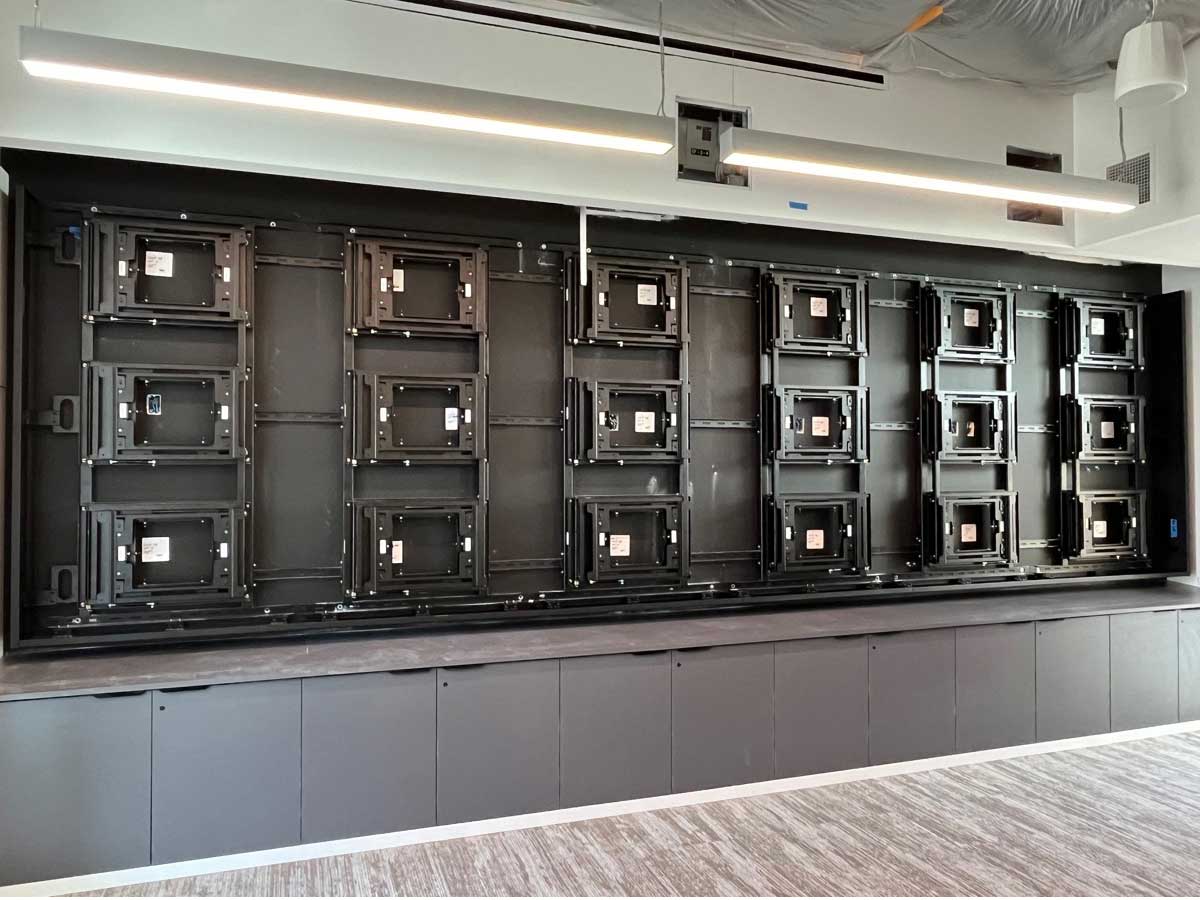 Front view of custom 6w x 3h wall attached visual structure to support eighteen 55in displays in landscape using an RPV swing mount solution (in progress)