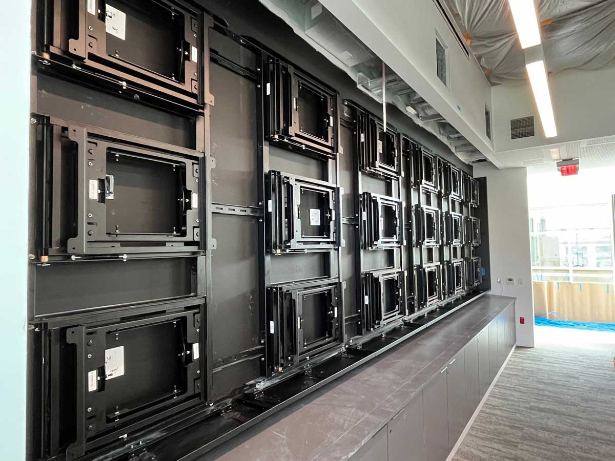 Angled view of custom 6w x 3h wall attached visual structure to support eighteen 55in displays in landscape using an RPV swing mount solution (in progress)