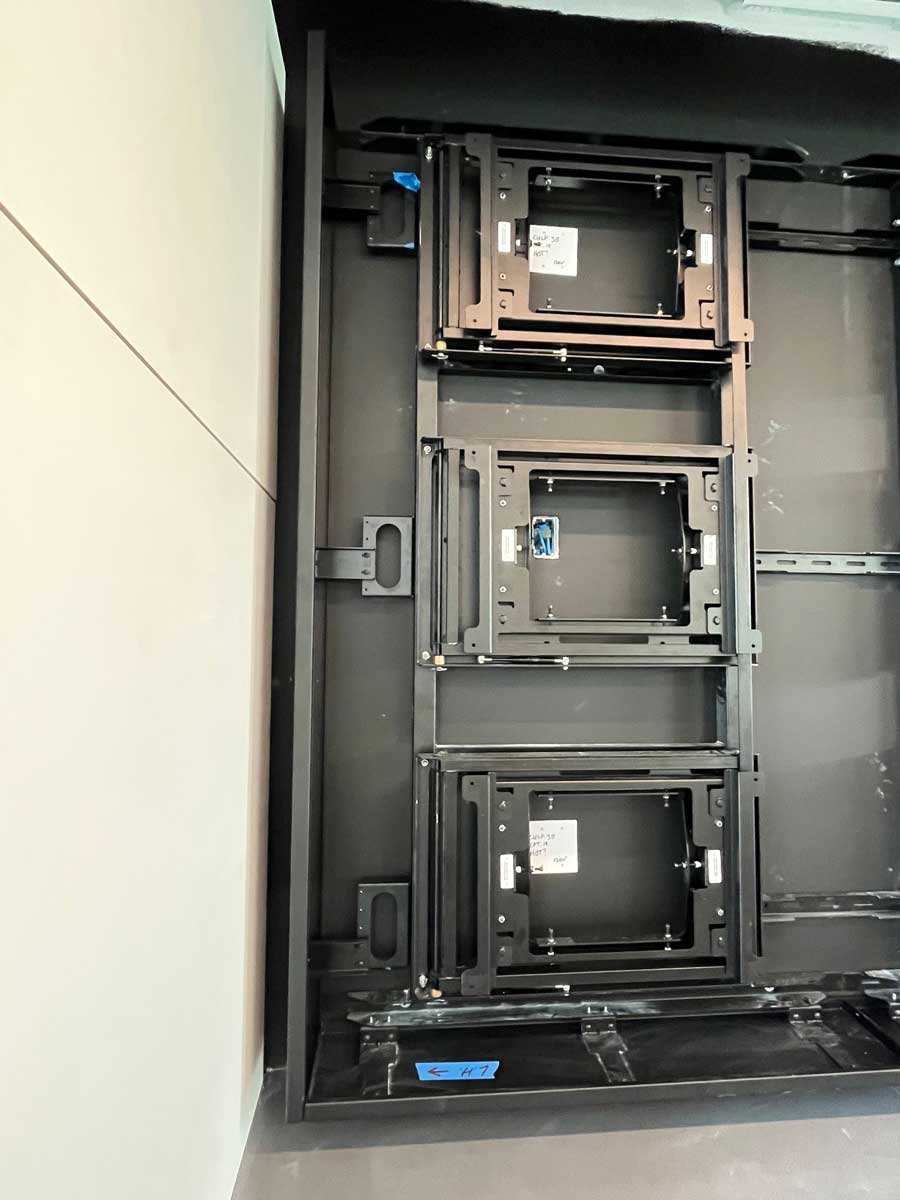 Close up view of custom 6w x 3h wall attached visual structure to support eighteen 55in displays in landscape using an RPV swing mount solution (in progress)