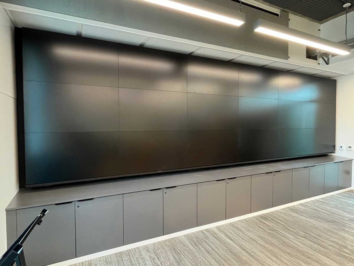 Photo of finished custom 6w x 3h wall attached visual structure to support eighteen 55in displays using an RPV swing mount solution