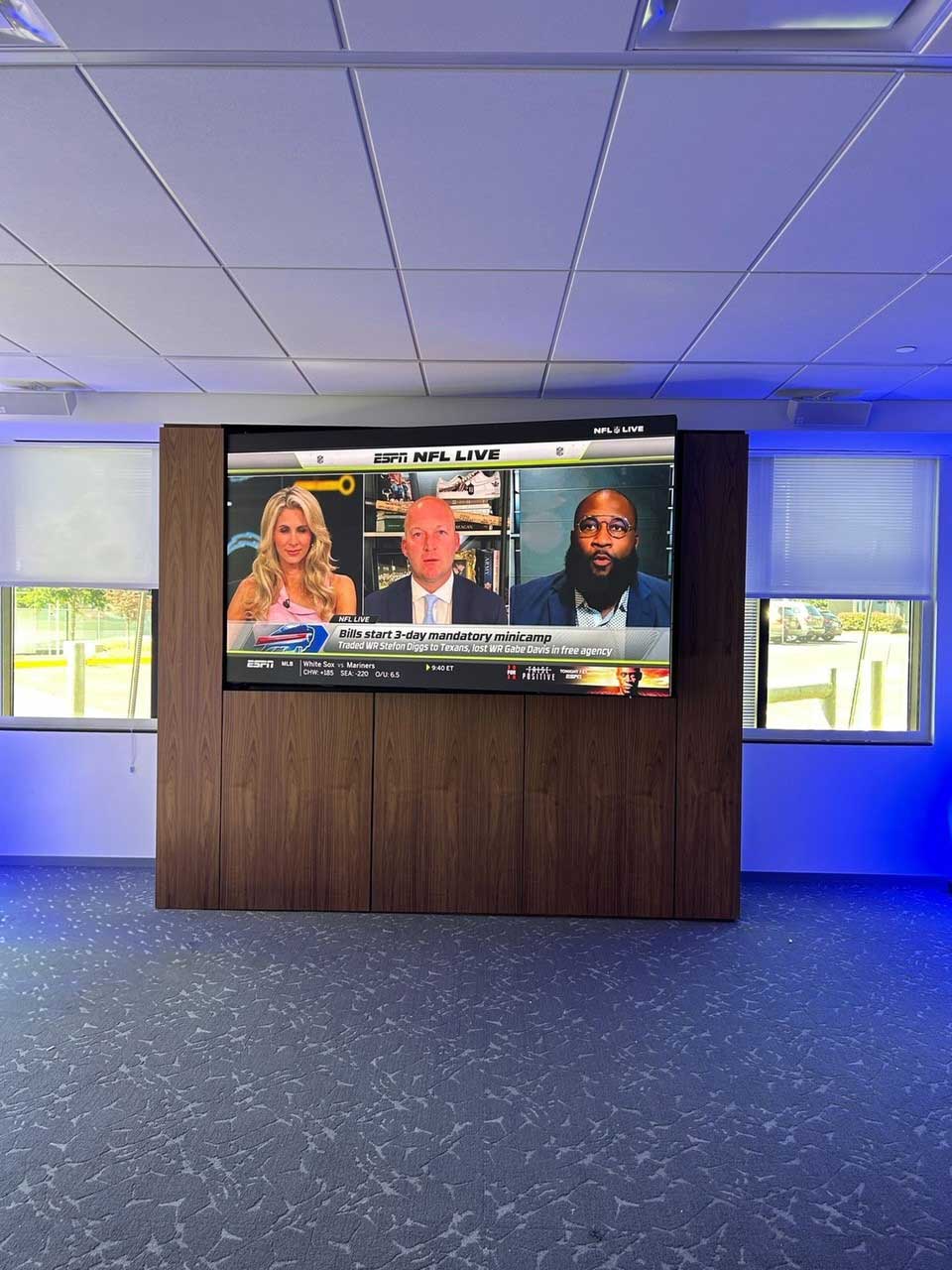 Finished product of a 4x4 floor-to-ceiling mounting structure with NFL Live showing on TV