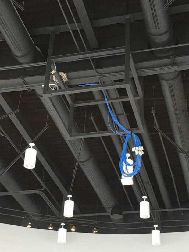 In progress photo of a ceiling suspended truss system with drawer slide service provisions for 8 projections (view of projection ports)