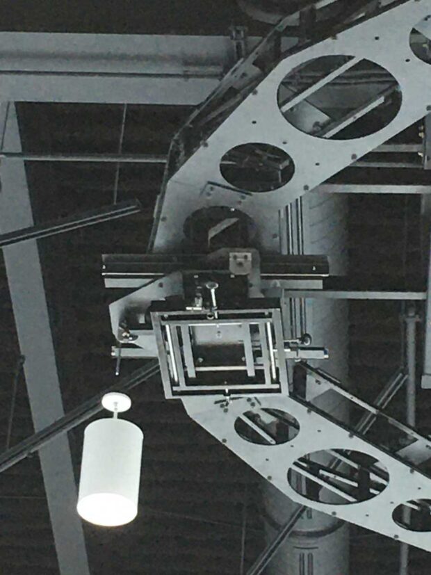 In progress photo of a ceiling suspended truss system with drawer slide service provisions for 8 projections (close up of slide mount)